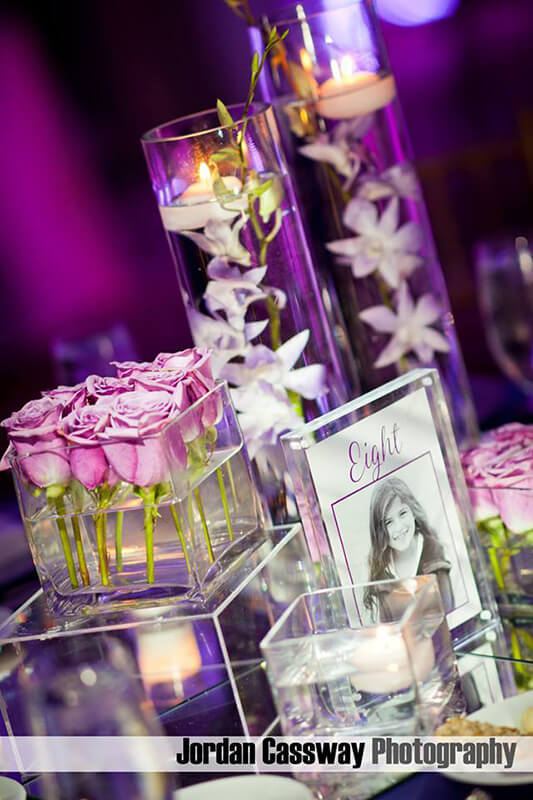 Clear acrylic boxes holding colorful statues stacked on top of each other on a white table.