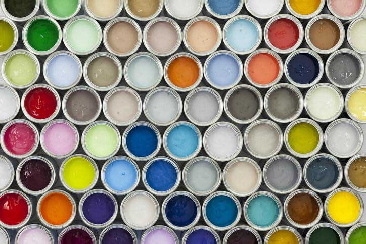 Assortment of multicolored open paint cans from a top view.