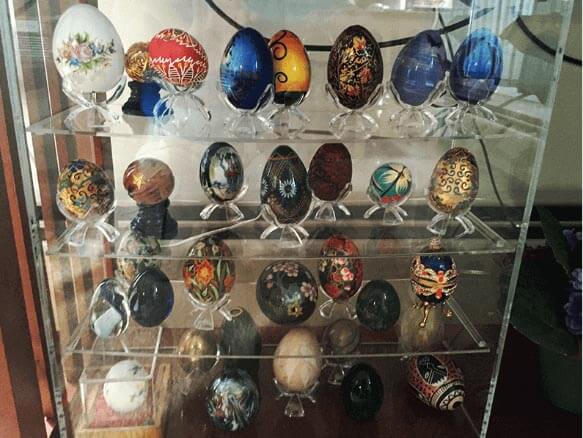 Clear acrylic display shelves holding unique painted eggs.
