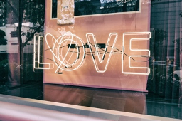Lighted "LOVE" sign in a window display.