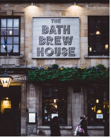 Storefront of "The Bath Brew House" with dim lighting.