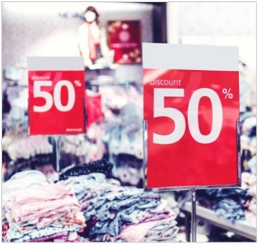Red "50% off" signs in a clothing store.