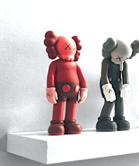 One red clown and one black and white clown on a white acrylic floating shelf.