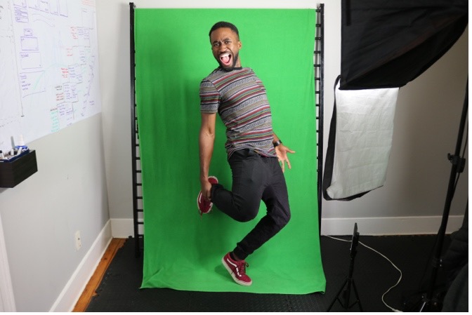 Man dancing in front of green screen backdrop.