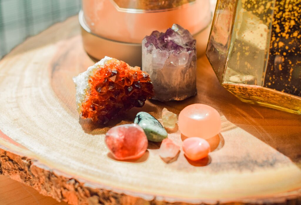 Colorful assorted crystals displayed on a raw wood circular table.