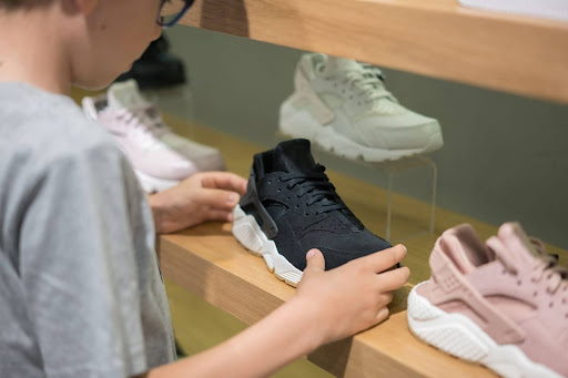boy looking at sneakers displayed on acrylic risers